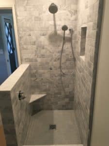 This image features a walk-in shower with grey tile.