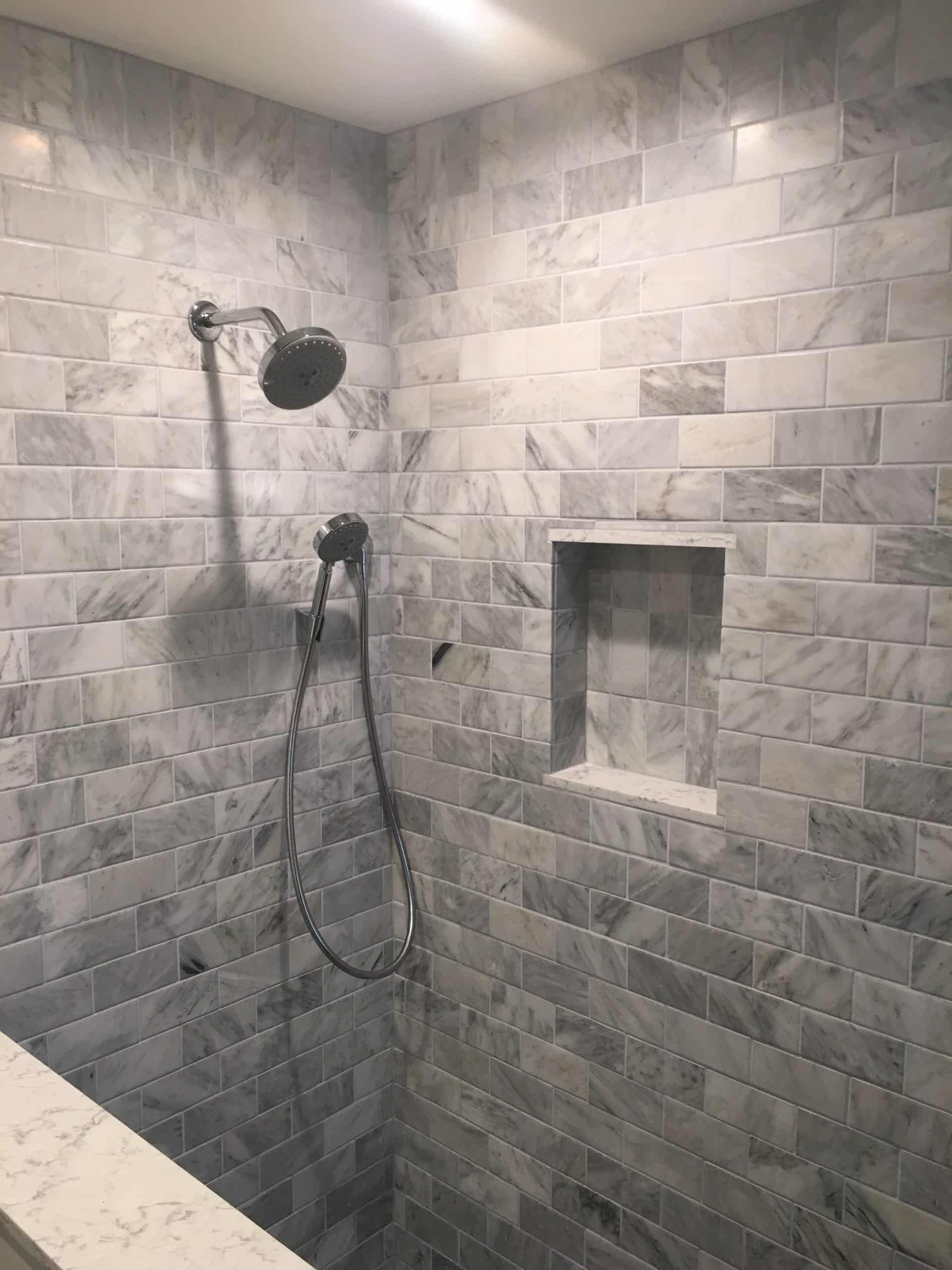 Features a large overhead showerhead and a handheld showerhead, as well as a built-in niche for storing bath products.