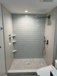 A bathroom with mixed tile patterns used.